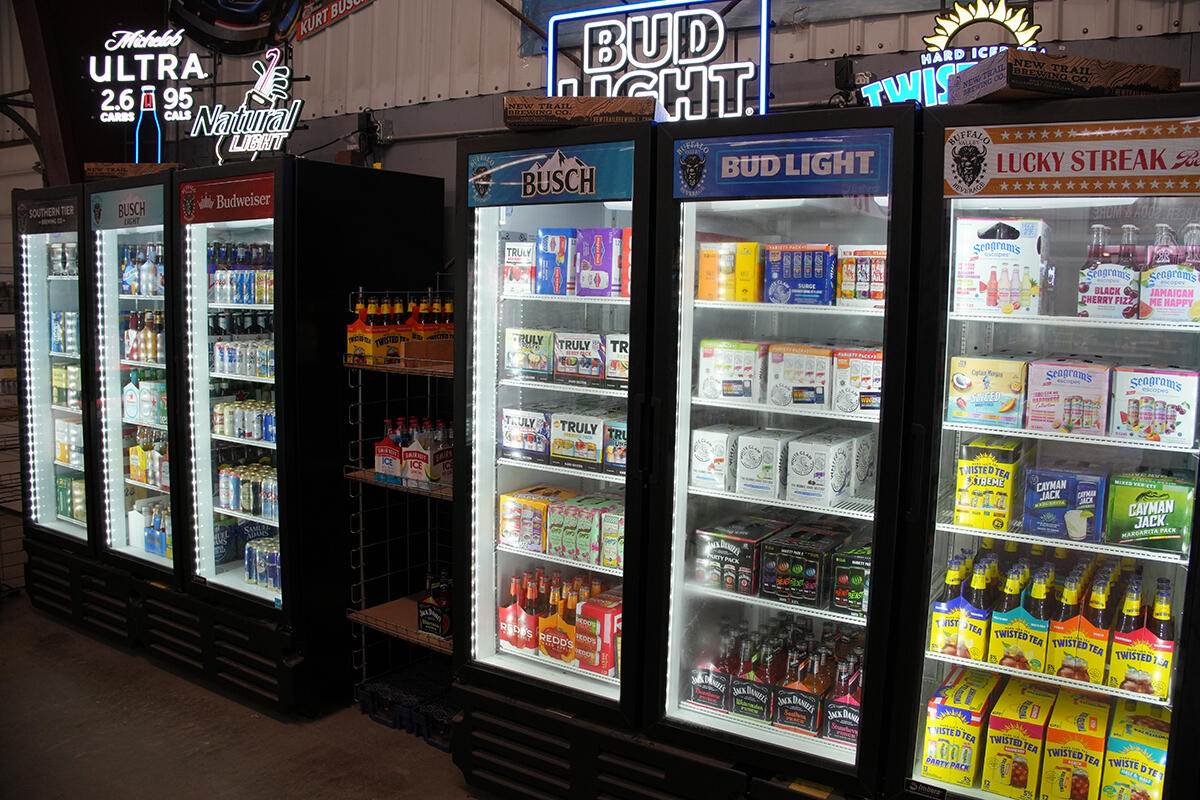 Hard seltzers, ciders, and canned beverages displayed in a store cooler.